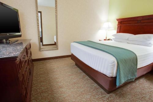 a hotel room with a bed and a flat screen tv at Pear Tree Inn St Louis Convention Center in Saint Louis