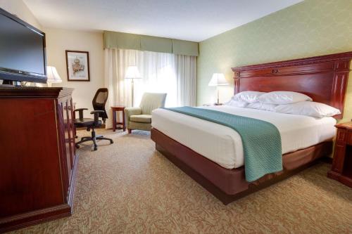 a hotel room with a bed and a flat screen tv at Pear Tree Inn St Louis Convention Center in Saint Louis