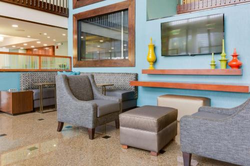 a waiting room with chairs and a tv on a wall at Drury Inn & Suites Birmingham Grandview in Birmingham