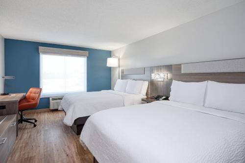 um quarto de hotel com duas camas e uma secretária e uma janela em Holiday Inn Express Hotel & Suites Columbia-I-20 at Clemson Road, an IHG Hotel em Columbia