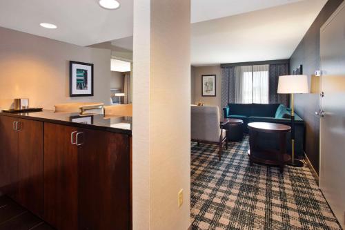 a hotel room with a kitchen and a living room at DoubleTree by Hilton Lansing in Lansing