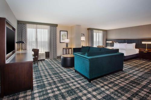 a hotel room with a bed and a couch at DoubleTree by Hilton Lansing in Lansing
