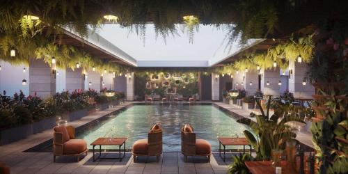 una piscina en un hotel con sillas y mesas en DoubleTree by Hilton Doha Downtown, en Doha