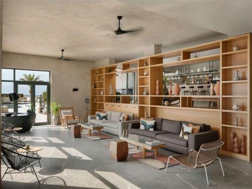 a living room with couches and chairs and tables at Domes Aulus Elounda All-Inclusive Resort, Curio by Hilton in Elounda