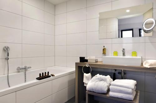 a bathroom with a tub and a sink and a bath tub at Fletcher Hotel-Restaurant Wings-Rotterdam in Rotterdam