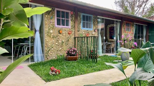 a house with a garden with flowers in the yard at Gruta da Sereia Suítes Ubatuba in Ubatuba