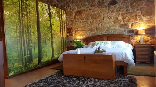 - une chambre avec un lit et une grande fenêtre arborée dans l'établissement Bubela finca, à Pontevedra