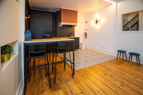- une cuisine avec un comptoir et des tabourets dans une pièce dans l'établissement VAGO Alcântara Suites, à Lisbonne