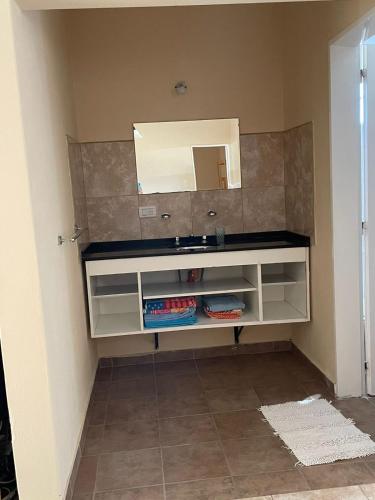 een badkamer met een wastafel en een spiegel bij Departamento Alta Gracia in Alta Gracia