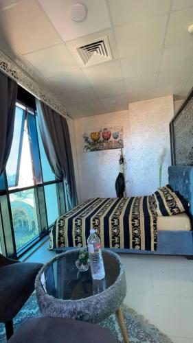 a hotel room with a bed and a table and a room at Luxe Studio Sea View in Oran