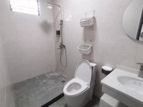 a bathroom with a toilet and a shower and a sink at Olioinn B&B in Wenchang