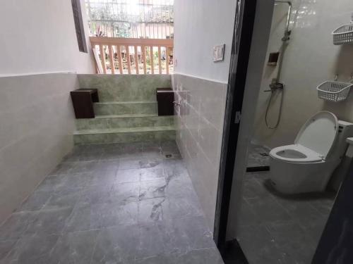 a bathroom with a toilet and stairs with a shower at Olioinn B&B in Wenchang