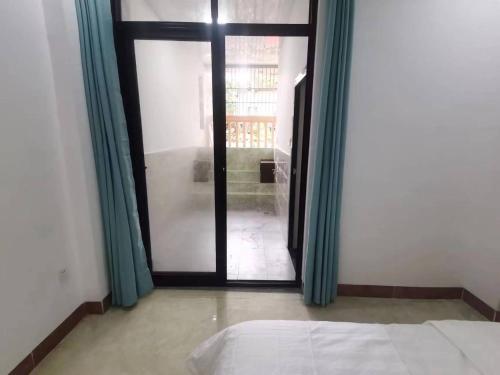 a bedroom with a bed and a sliding glass door at Olioinn B&B in Wenchang