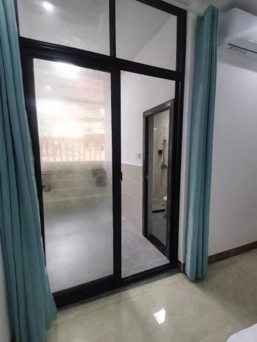 a room with a glass door and a mirror at Olioinn B&B in Wenchang