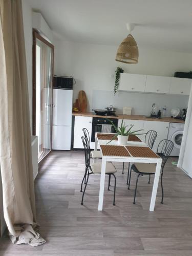 a kitchen with a table and chairs in a room at Villa93 in Villepinte