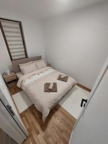 Un pequeño dormitorio con una cama con dos sombreros. en DivčiNova B7 Jovanovic, en Divčibare