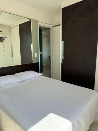 1 Schlafzimmer mit 2 Betten und einem großen Spiegel in der Unterkunft Apartamento perto da praia em Itapoã in Vila Velha