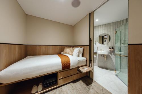 1 dormitorio con cama y ducha en Aerotel Sydney (Arrivals B, International Terminal 1) en Sídney