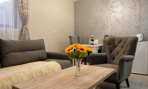 a living room with a table with a vase of flowers at Villa Zagorka and mountain houses A, M, D in Kopaonik