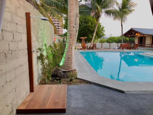 a swimming pool with a palm tree next to a building at Pousada Jardins in Santarém