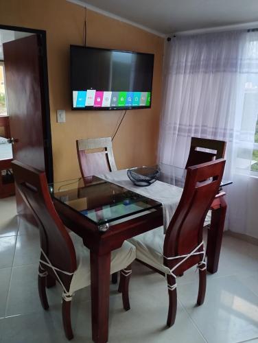 a dining room with a glass table and chairs at Apartamento con vista a la ciudad en barrio campo hermoso 301 in Bucaramanga