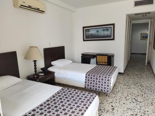 a hotel room with two beds and a table at Hotel Estación by Destino Pacifico in Buenaventura