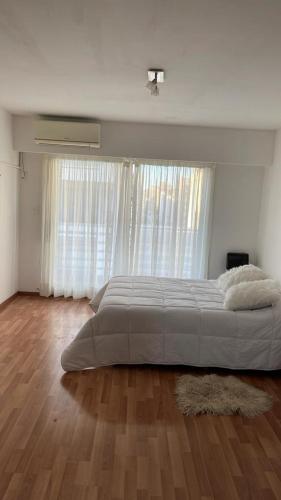 a bedroom with a large bed in front of a window at Ruffus´s Apple Rosario in Rosario