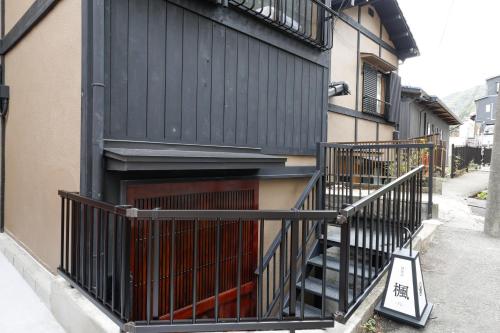 a building with a black fence next to a staircase at 貸別荘 楓-Fū- 有馬 in Arima