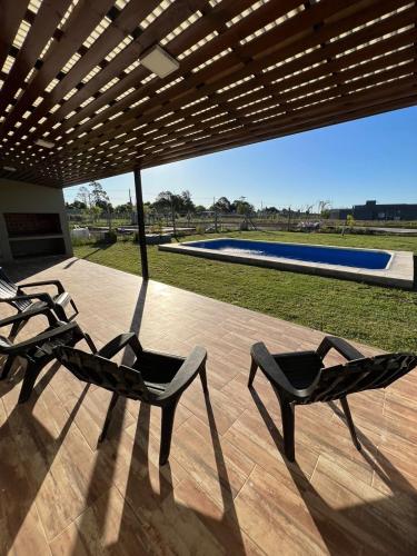 - deux chaises sur une terrasse avec piscine dans l'établissement Casa quinta con entorno rural, à Chacabuco