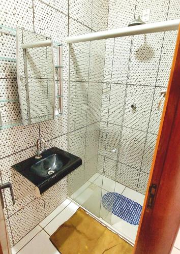 a bathroom with a sink and a glass shower at Aconchego do Caranã in Salinópolis