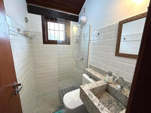 a bathroom with a sink and a toilet and a mirror at Studio 6 in Búzios