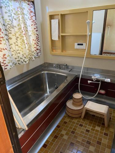 un piccolo bagno con vasca e servizi igienici di 田舎庵 a Hanyu