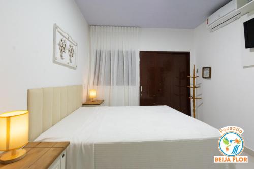 a bedroom with a large white bed in a room at Pousada Beija-Flor in Chapada dos Guimarães