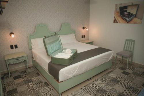 ein Schlafzimmer mit einem Bett mit einem Koffer drauf in der Unterkunft Añoranza Hotel Boutique in Ciudad Hidalgo
