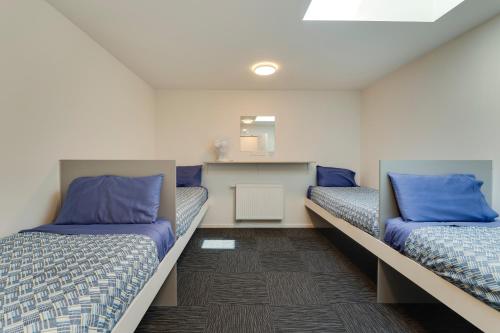 two beds in a room with blue pillows at Falcon's Nest in Cromwell