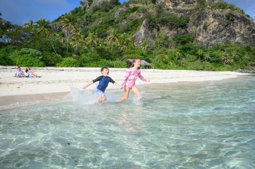 two children playing in the water on the beach at Sheraton Resort & Spa, Tokoriki Island, Fiji in Tokoriki