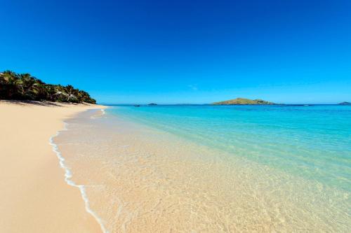 a sandy beach with the ocean and a blue sky at Sheraton Resort & Spa, Tokoriki Island, Fiji in Tokoriki