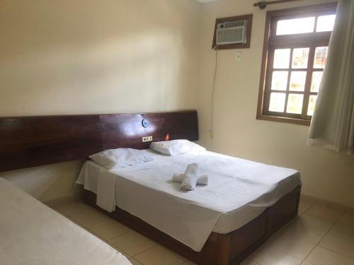 ein Schlafzimmer mit einem Bett mit zwei Handtüchern darauf in der Unterkunft Apartamento do Mário 128D in Porto Seguro