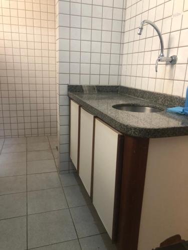 ein Bad mit einem Waschbecken und Fliesenboden in der Unterkunft Apartamento do Mário 128D in Porto Seguro