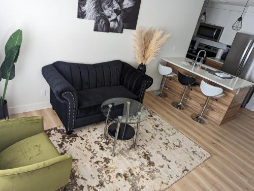 a living room with a black couch and a table at Comfy 2BR condo in Seton, Southeast Calgary in Calgary