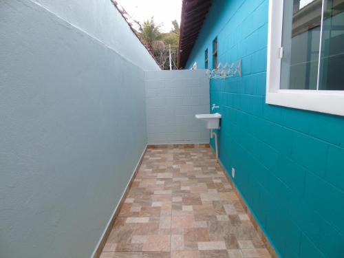 a bathroom with a blue wall and a toilet at Mare de Lua Boraceia in Boracéia