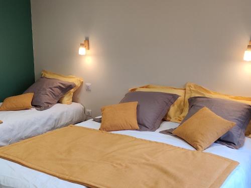 two beds with pillows on them in a room at Gîte rénové avec piscine intérieure, accessible PMR, en plein cœur du Bocage Vendéen. - FR-1-426-536 in Cheffois