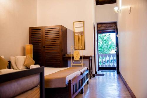 a bedroom with a bed and a window and a room at Salty Seahorse Mount Lavinia in Watumulla