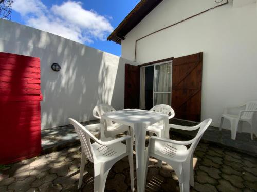 una mesa blanca y sillas en un patio en Complejo Quimey alojamiento familiar en Villa Gesell