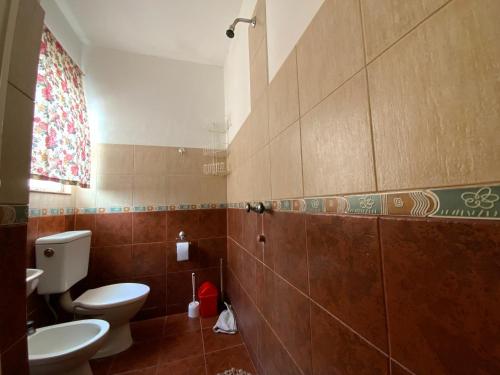 y baño con aseo y lavamanos. en Complejo Quimey alojamiento familiar en Villa Gesell