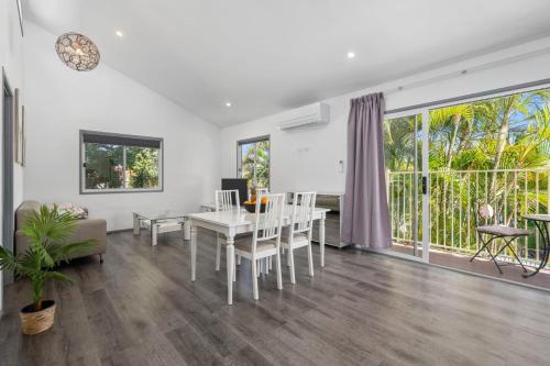 a living room with a table and chairs and a dining room at Tropical 2-bedroom Guesthouse, Pool, Sauna in Tanah Merah