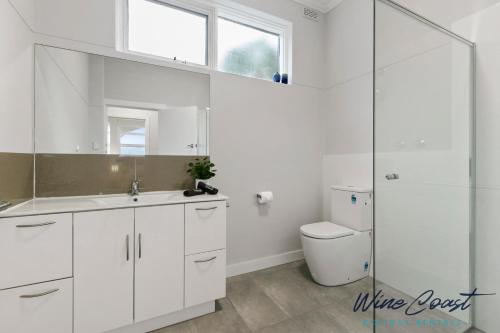 uma casa de banho branca com um lavatório e um WC em Wave N Sea Shore by Wine Coast Holidays em Christies Beach