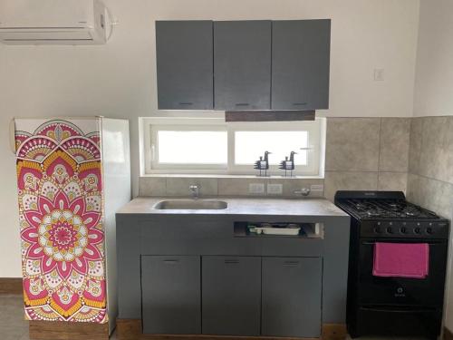 a kitchen with a sink and a stove at La Higuera con Parking B in Azul
