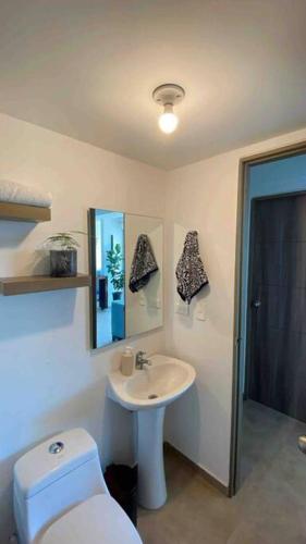 a bathroom with a white sink and a toilet at Alojamiento en Pereira in Pereira