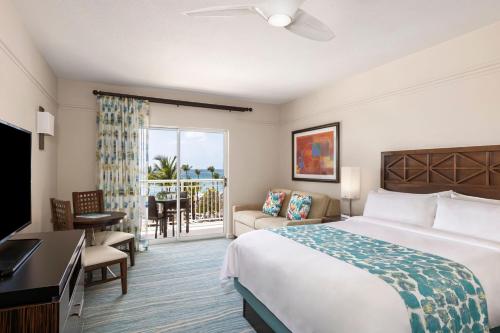 a hotel room with a bed and a balcony at Marriott's Aruba Surf Club in Palm-Eagle Beach